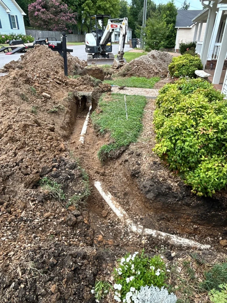 Trench opened across a Crieve Hall yard for a new sewer main