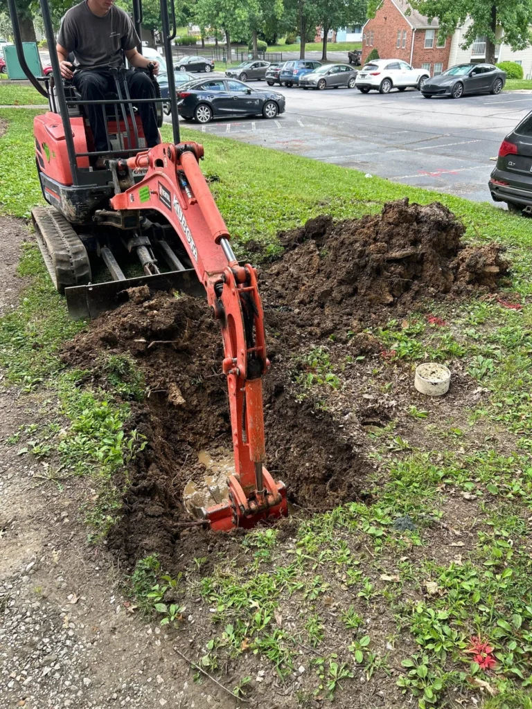 Mini excavator opening the ground to reach a leaking water line in Donelson