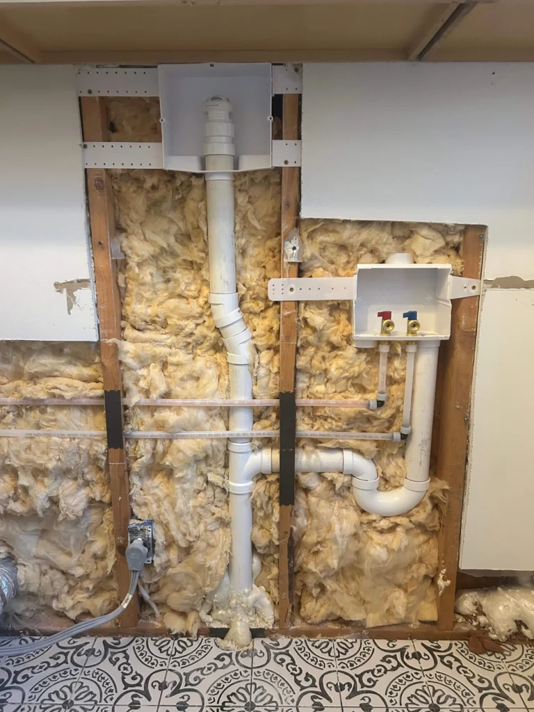 New drain and vent stack roughed in behind an open wall in Brentwood