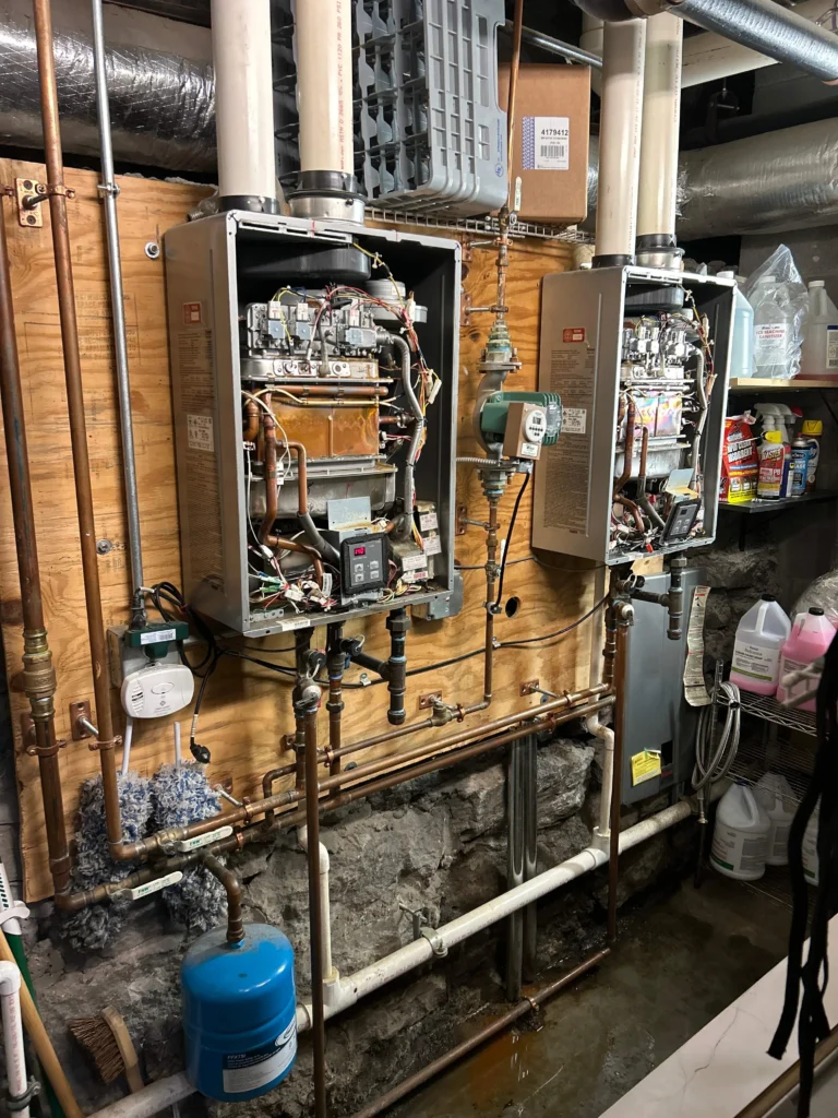 Commercial tankless water heaters mounted on a wall with gas and water piping in Nashville