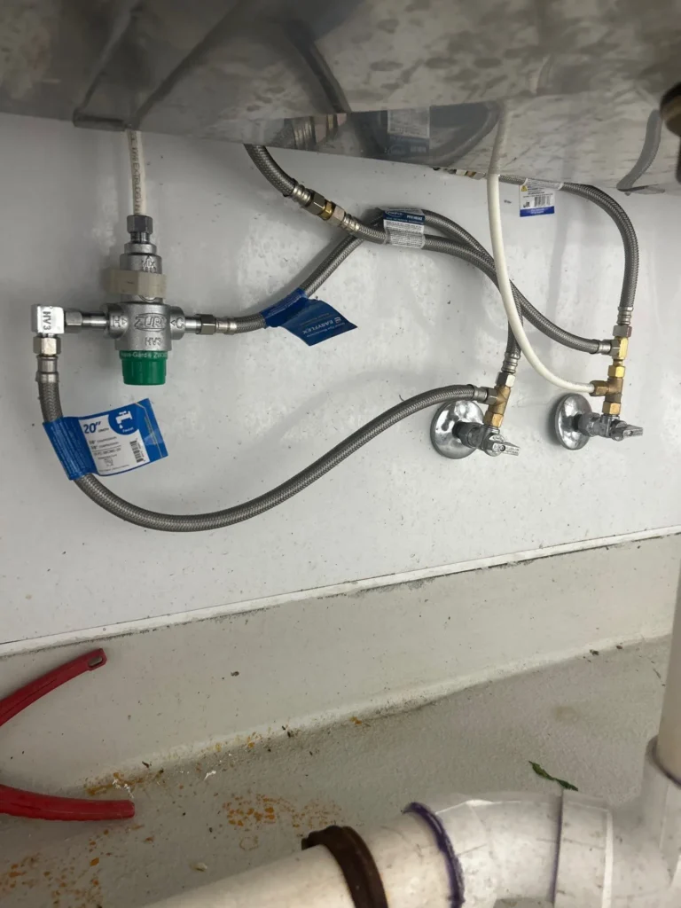 New shutoff valves and braided supply lines under a restaurant prep sink in Nashville