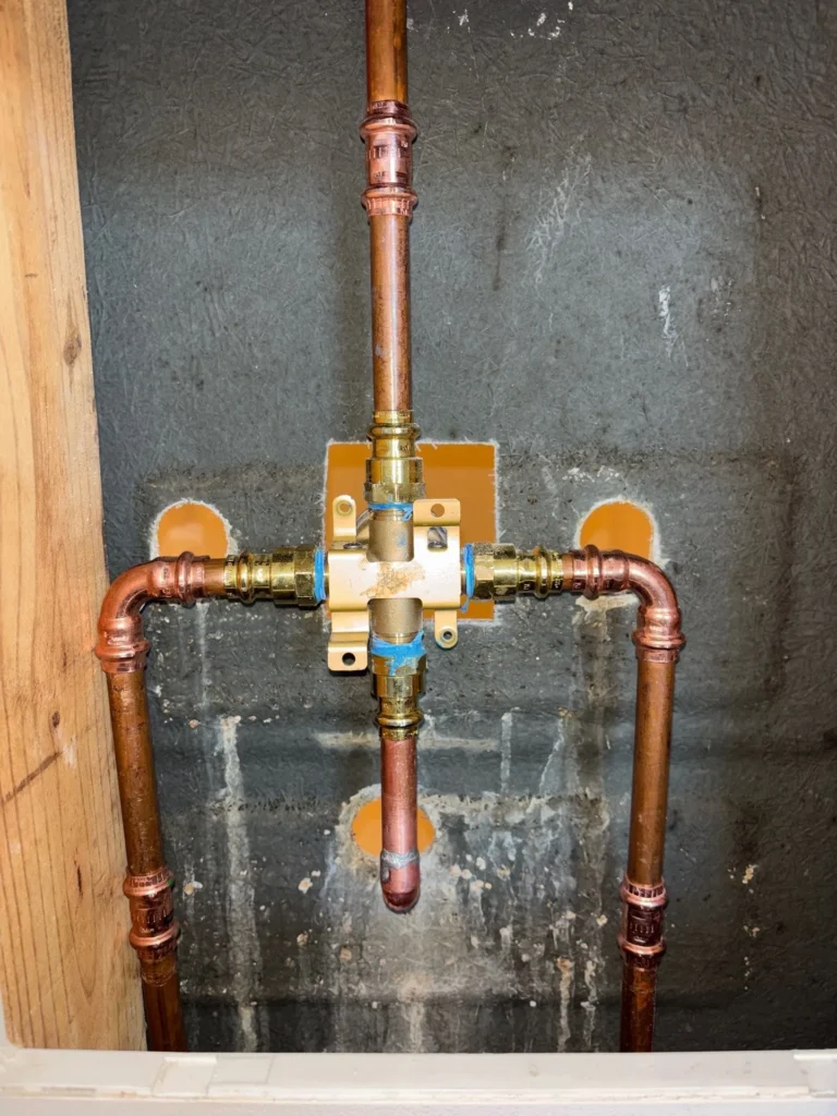 Copper supply lines roughed in behind the wall in La Vergne